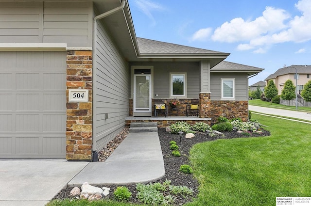 504 S 198th St, Elkhorn, NE 68022 - entrance to property featuring stone siding, a lawn, roof with shingles, an attached garage, and covered porch