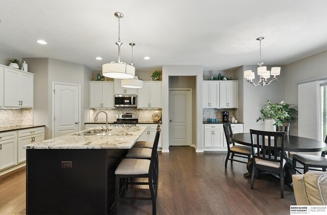 504 S 198th St, Elkhorn, NE 68022 - kitchen with stainless steel appliances, a sink, tasteful backsplash, a chandelier, and dark wood finished floors