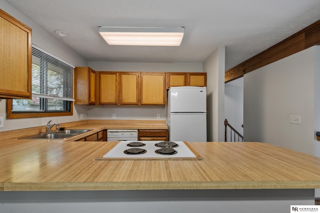 2211 Scarborough Dr, Bellevue, NE 68123 - kitchen with white appliances, a sink, light countertops, and a peninsula