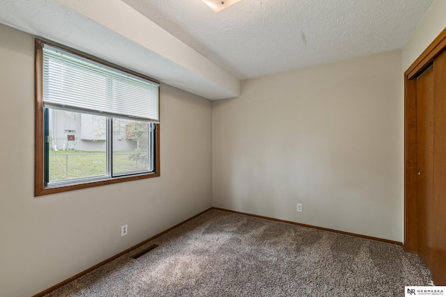 2211 Scarborough Dr, Bellevue, NE 68123 - unfurnished bedroom with carpet floors, multiple windows, baseboards, a closet, and a textured ceiling