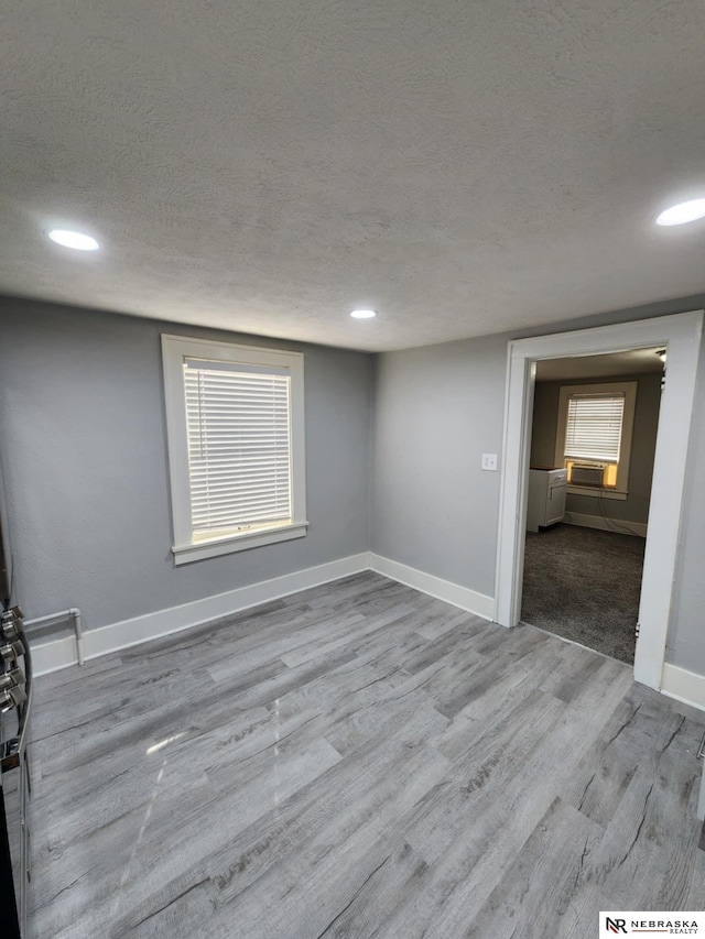 1535 N 32nd St, Lincoln, NE 68503 - empty room featuring a textured ceiling, wood finished floors, baseboards, and recessed lighting