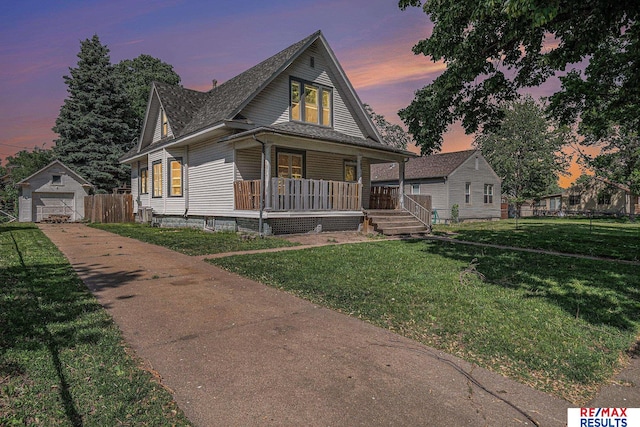 240 E 15th St, Fremont, NE 68025 - view of front of house featuring concrete driveway, a porch, a garage, an outdoor structure, and a shingled roof