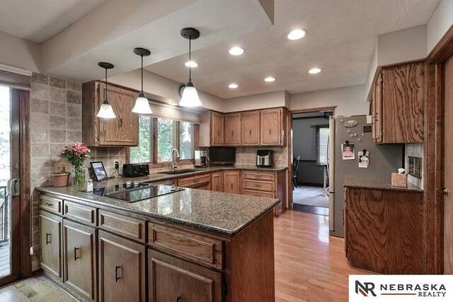 15708 Leavenworth St, Omaha, NE 68118 - kitchen with a peninsula, a sink, black electric stovetop, backsplash, and recessed lighting