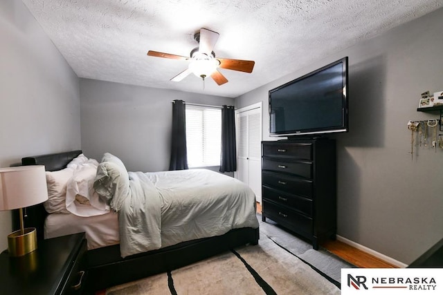 15708 Leavenworth St, Omaha, NE 68118 - bedroom with a closet, a textured ceiling, a ceiling fan, and baseboards