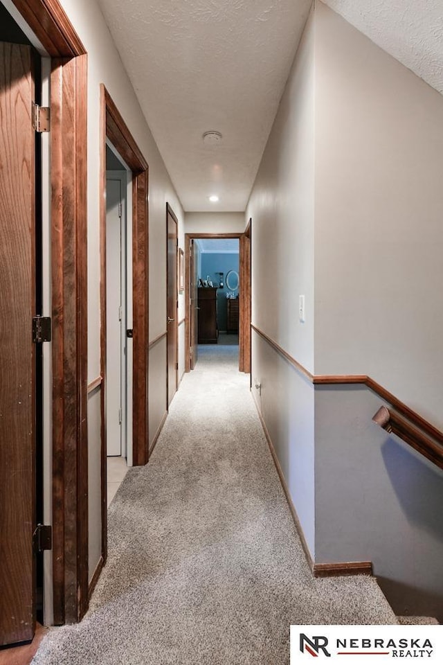 15708 Leavenworth St, Omaha, NE 68118 - hall with carpet flooring, a textured ceiling, an upstairs landing, and baseboards