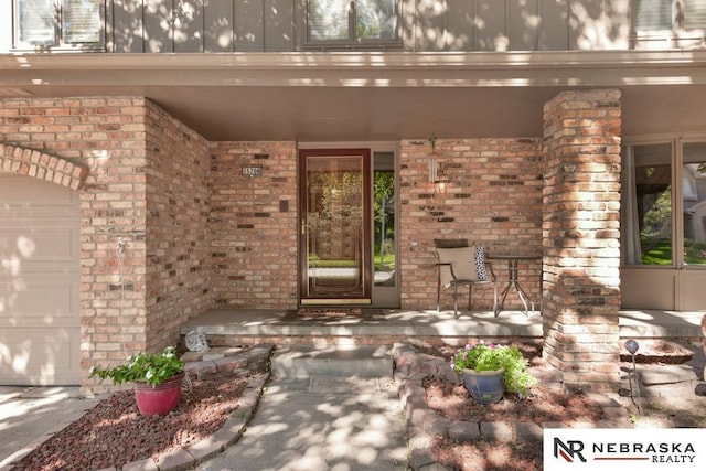 15708 Leavenworth St, Omaha, NE 68118 - property entrance with covered porch, brick siding, a garage, and board and batten siding