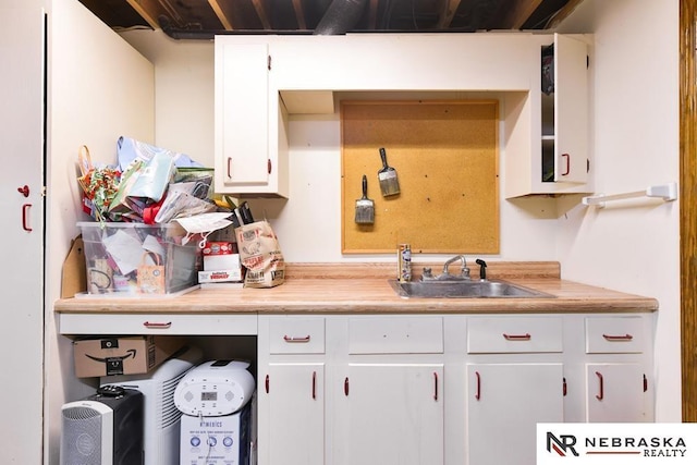 15708 Leavenworth St, Omaha, NE 68118 - kitchen with a sink, light countertops, and white cabinetry