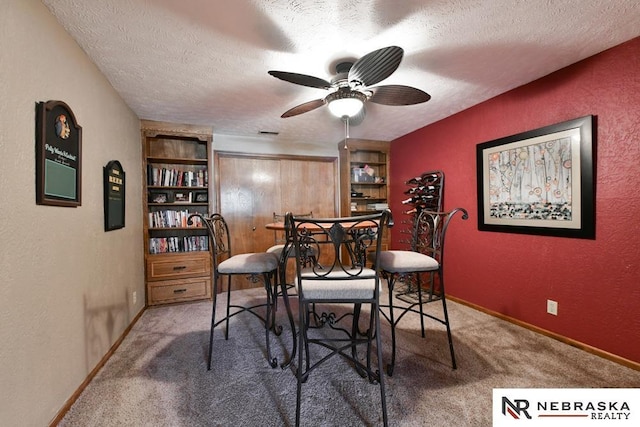15708 Leavenworth St, Omaha, NE 68118 - carpeted dining area featuring a textured ceiling, a textured wall, baseboards, ceiling fan, and built in shelves