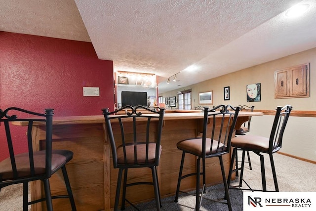 15708 Leavenworth St, Omaha, NE 68118 - indoor dry bar featuring a textured ceiling, carpet floors, a textured wall, and baseboards