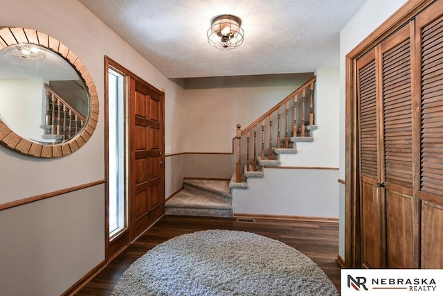15708 Leavenworth St, Omaha, NE 68118 - entrance foyer with baseboards, stairs, dark wood-style flooring, and a textured ceiling