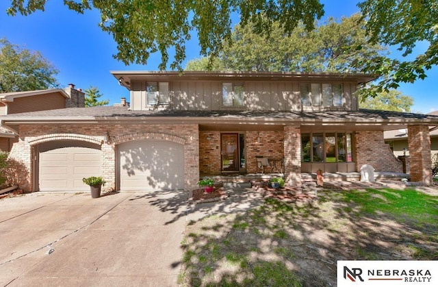 15708 Leavenworth St, Omaha, NE 68118 - view of front of house featuring concrete driveway, brick siding, and a chimney
