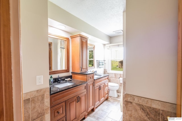 13205 N 192nd St, Bennington, NE 68007 - full bath featuring toilet, vanity, tile walls, and a textured ceiling