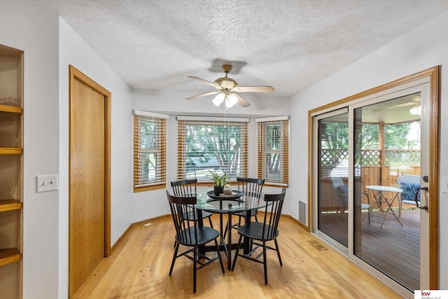 14460 Patrick Ave, Omaha, NE 68116 - dining area featuring light wood finished floors, a ceiling fan, baseboards, and a textured ceiling