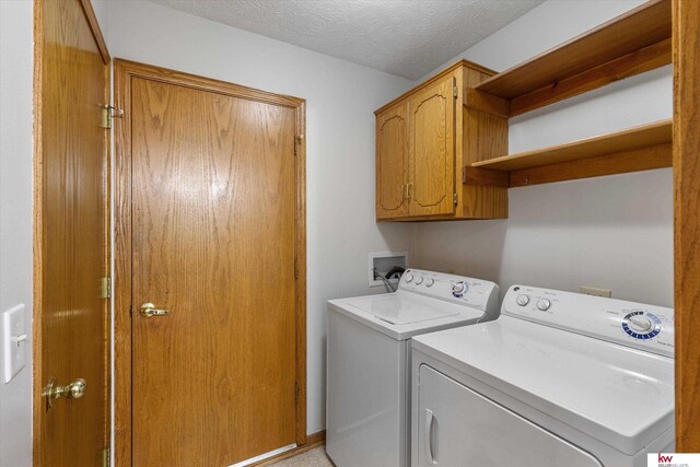 14460 Patrick Ave, Omaha, NE 68116 - washroom with cabinet space, washer and clothes dryer, and a textured ceiling