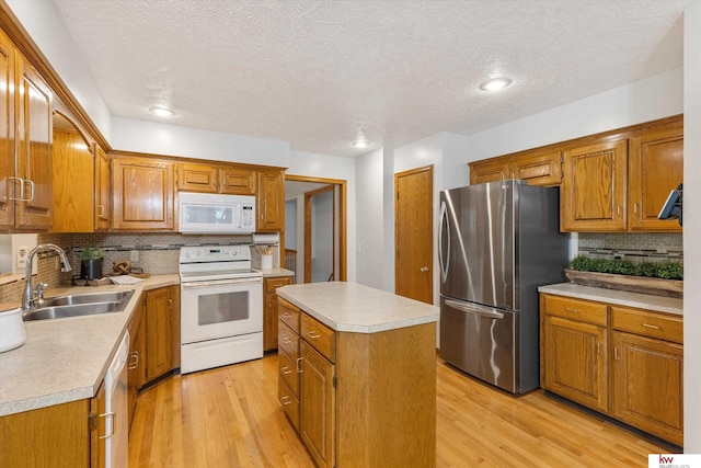 14460 Patrick Ave, Omaha, NE 68116 - kitchen featuring white appliances, a sink, light wood-style flooring, brown cabinets, and decorative backsplash