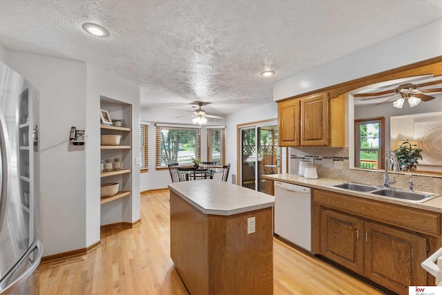 14460 Patrick Ave, Omaha, NE 68116 - kitchen featuring dishwasher, a sink, ceiling fan, brown cabinetry, and a textured ceiling