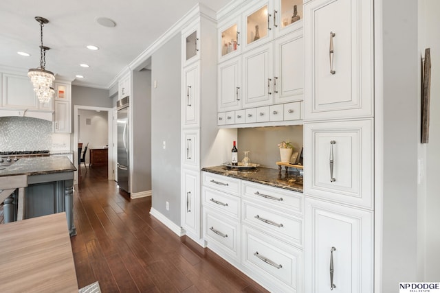 15921 Lake St, Omaha, NE 68116 - kitchen with built in refrigerator, baseboards, dark stone counters, glass insert cabinets, and dark wood-style floors