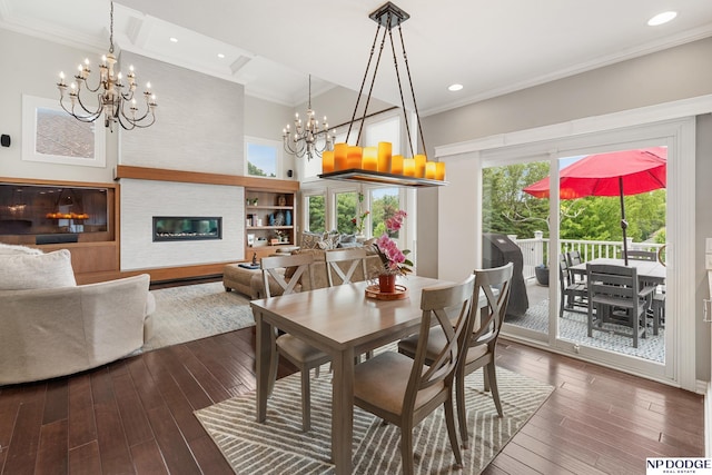 15921 Lake St, Omaha, NE 68116 - dining space with a chandelier, crown molding, dark wood finished floors, a glass covered fireplace, and recessed lighting
