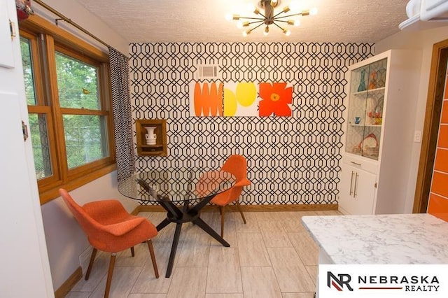 3840 X St, Lincoln, NE 68503 - dining area with a chandelier, a textured ceiling, and baseboards