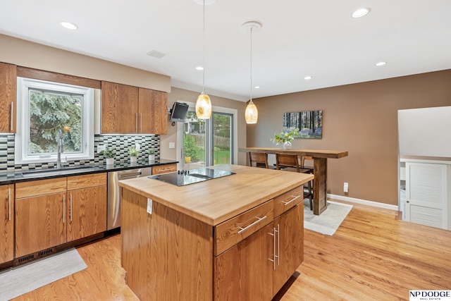 9911 Devonshire Dr, Omaha, NE 68114 - kitchen featuring stainless steel dishwasher, butcher block countertops, a sink, light wood-type flooring, and tasteful backsplash
