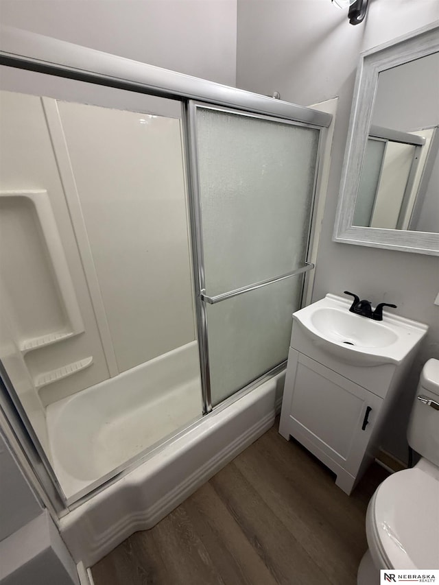 1322 S 21st St, Omaha, NE 68108 - bathroom featuring toilet, wood finished floors, vanity, and bath / shower combo with glass door