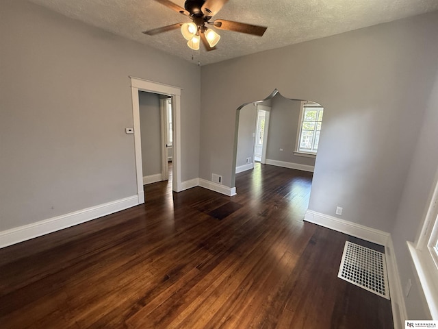 1322 S 21st St, Omaha, NE 68108 - unfurnished room featuring arched walkways, ceiling fan, dark wood-style flooring, a textured ceiling, and baseboards