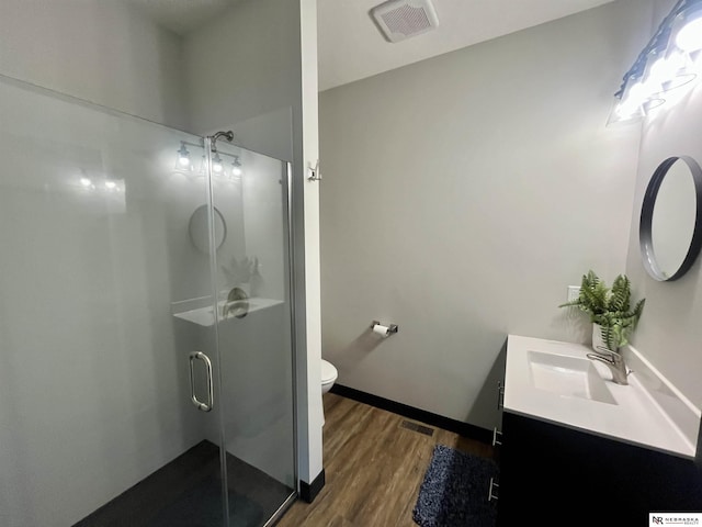 1001 Trail Dr, Valentine, NE 69201 - bathroom with vanity, wood finished floors, a stall shower, toilet, and baseboards