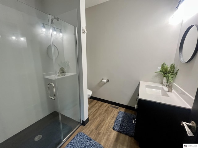 1001 Trail Dr, Valentine, NE 69201 - full bath featuring vanity, wood finished floors, toilet, a shower stall, and baseboards