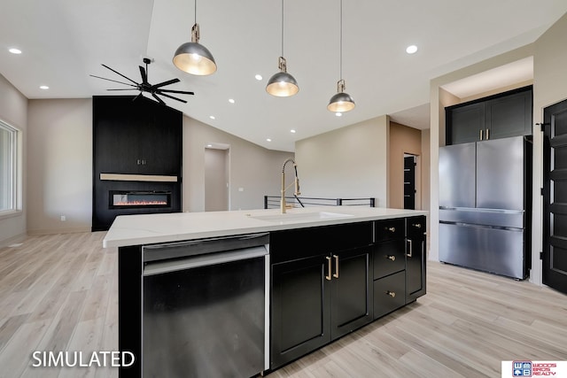 9350 S 86th St, Lincoln, NE 68526 - kitchen with appliances with stainless steel finishes, a sink, light wood-style flooring, dark cabinetry, and vaulted ceiling