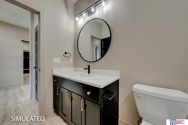 9350 S 86th St, Lincoln, NE 68526 - bathroom with toilet, vanity, baseboards, and wood finished floors