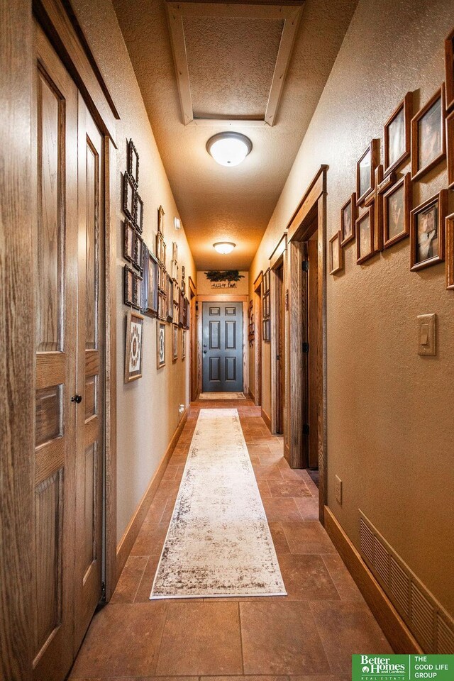 3860 Shady Bend Rd, Grand Island, NE 68801 - hallway with stone tile flooring, baseboards, and a textured wall