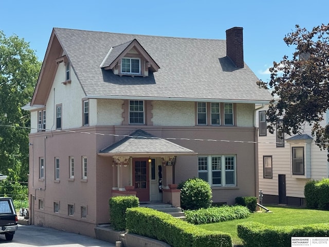 115 N 38th Ave, Omaha, NE 68131 - view of front of home featuring a chimney, covered porch, brick siding, and a front lawn