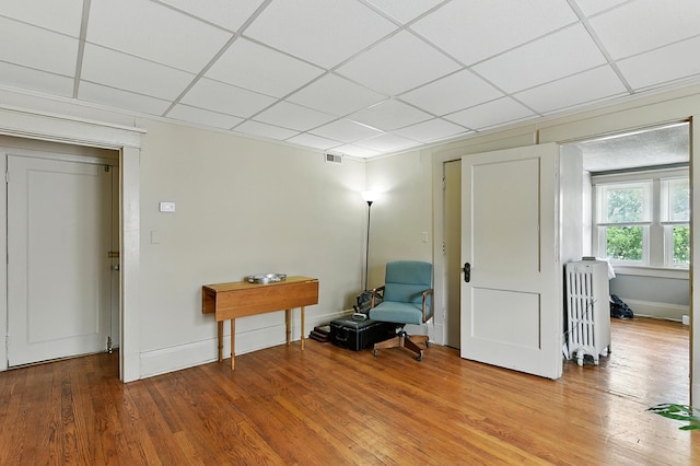 115 N 38th Ave, Omaha, NE 68131 - living area with radiator, wood finished floors, and a drop ceiling