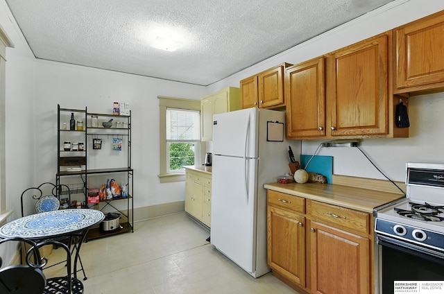 115 N 38th Ave, Omaha, NE 68131 - kitchen featuring gas stove, freestanding refrigerator, a textured ceiling, light countertops, and brown cabinetry