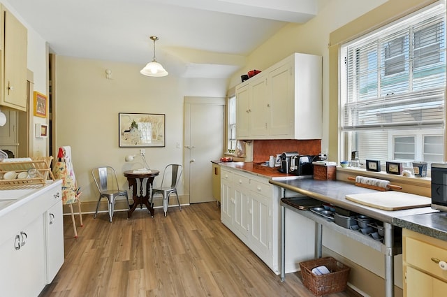 115 N 38th Ave, Omaha, NE 68131 - kitchen with healthy amount of natural light, light wood-style flooring, hanging light fixtures, and white cabinetry