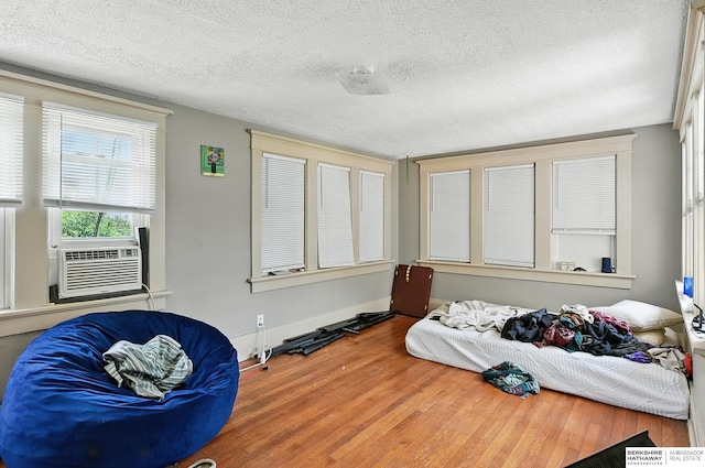 115 N 38th Ave, Omaha, NE 68131 - living area featuring cooling unit, a textured ceiling, and wood finished floors