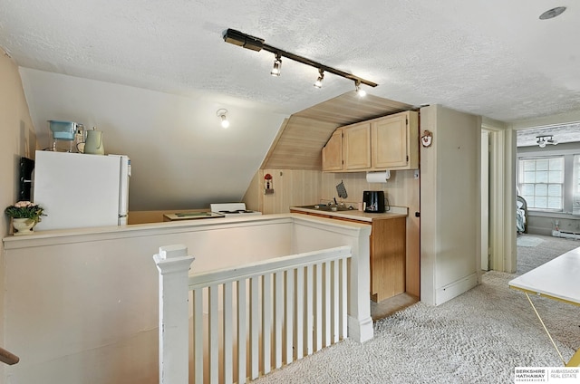 115 N 38th Ave, Omaha, NE 68131 - kitchen featuring freestanding refrigerator, light carpet, vaulted ceiling, a textured ceiling, and track lighting