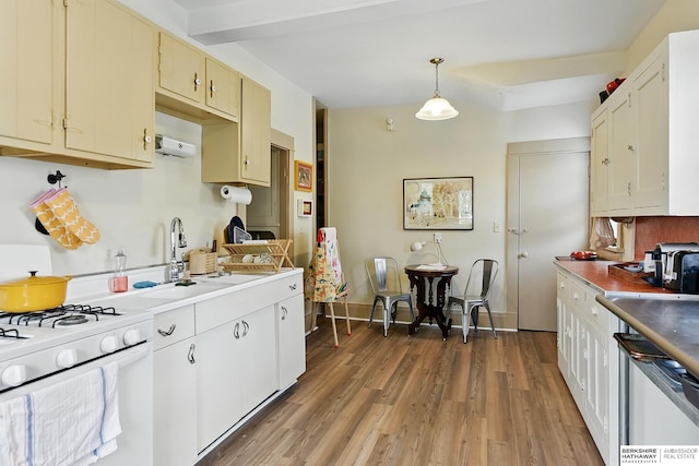 115 N 38th Ave, Omaha, NE 68131 - kitchen featuring white range with gas stovetop, light wood finished floors, dishwashing machine, beam ceiling, and decorative light fixtures