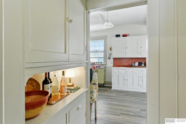 115 N 38th Ave, Omaha, NE 68131 - bar featuring light wood-style flooring, hanging light fixtures, and tasteful backsplash
