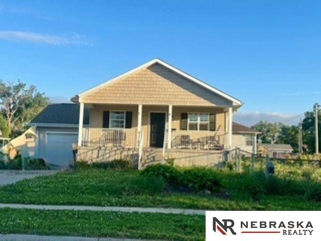 1703 Manderson St, Omaha, NE 68110 - bungalow featuring covered porch and a garage