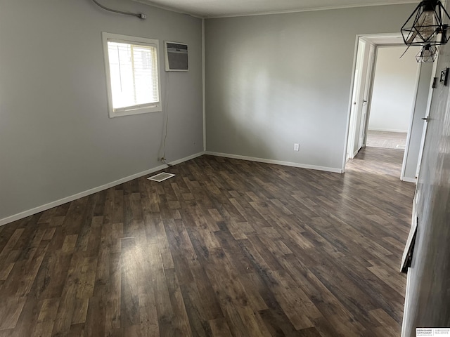 6796 Charles St, Omaha, NE 68132 - unfurnished room with a wall mounted AC, a chandelier, baseboards, dark wood finished floors, and ornamental molding