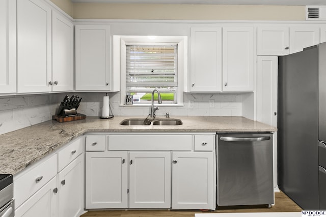 2026 N Park Ave, Fremont, NE 68025 - kitchen featuring appliances with stainless steel finishes, a sink, white cabinets, light stone countertops, and decorative backsplash