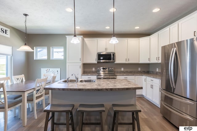 5614 N 177th St, Omaha, NE 68116 - kitchen with appliances with stainless steel finishes, a sink, dark wood-style flooring, white cabinets, and recessed lighting