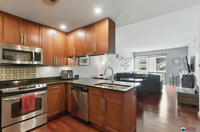 3201 Dodge Ct Unit 5412, Omaha, NE 68131 - kitchen featuring appliances with stainless steel finishes, a sink, dark wood-type flooring, and dark stone counters