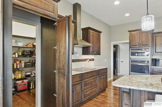 235 N 10th Ave, Springfield, NE 68059 - kitchen featuring wall chimney range hood, black electric cooktop, light wood-style flooring, backsplash, and recessed lighting