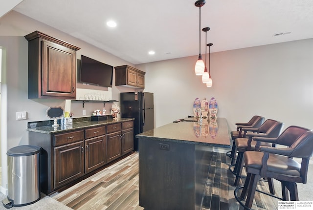 235 N 10th Ave, Springfield, NE 68059 - kitchen with light wood-style floors, pendant lighting, freestanding refrigerator, recessed lighting, and a kitchen bar