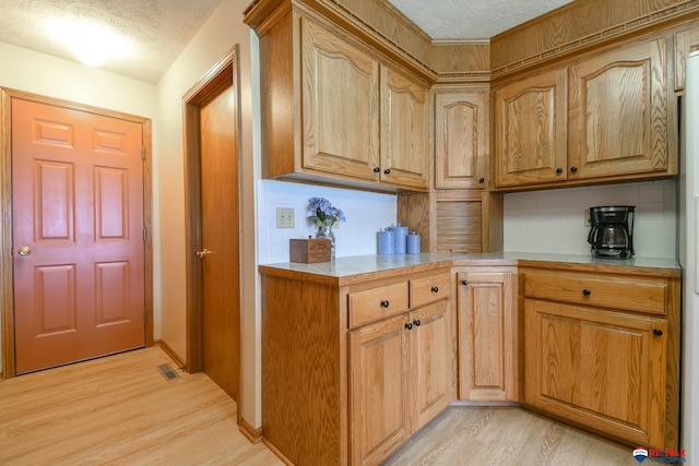1405 Euclid St, Ashland, NE 68003 - kitchen featuring light wood-type flooring, a textured ceiling, light countertops, and tasteful backsplash