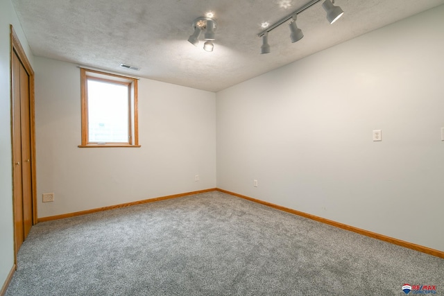 1405 Euclid St, Ashland, NE 68003 - unfurnished bedroom with carpet, baseboards, a textured ceiling, and track lighting
