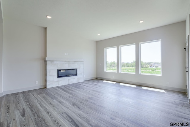 20145 S St, Omaha, NE 68135 - unfurnished living room with light wood-style flooring, baseboards, a tiled fireplace, and recessed lighting
