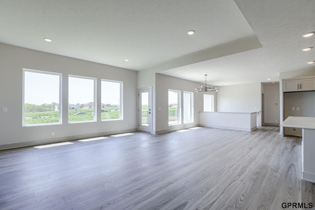 20145 S St, Omaha, NE 68135 - unfurnished living room featuring light wood-style floors, baseboards, recessed lighting, and a chandelier